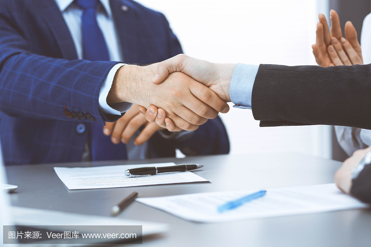 商人們握手,完成一份文件簽名。會(huì)議、合同及律師咨詢理念